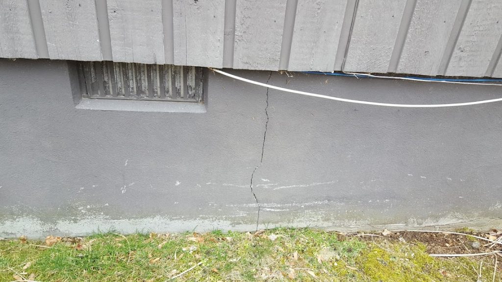 footer structural damage with crack going from bottom to top of foundation footer