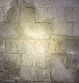 crack in brick wall going along edge of bricks